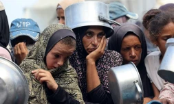 Des Palestiniens attendent une distribution de repas à Khan Younès, dans le sud de la bande de Gaza, le 21 août 2025