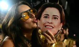 Une femme embrasse le masque de l'actrice brésilienne Fernanda Torres au sambodrome, durant le carnaval de Rio  le 3 mars 2025