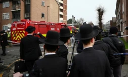 Des habitants sont rassemblés près d'un camion de pompiers après une attaque "antisémite" à Londres ayant visé quatre ambulances gérées par une association juive, le 23 mars 2026
