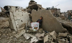Un enfant avec quelques jouets récupérés dans les décombres de sa maison le 17 décembre 2016 à rubble of his house in Aleppo's Al-Arkoub dans la banlieue d'Alep