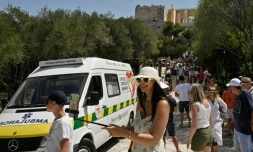 Des touristes devant l'entrée de l'Acropole après sa fermeture, le 20 juillet 2023 à Athènes, lors d'une vague de chaleur en Grèce
