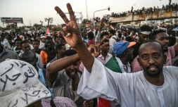 Des manifestants soudanais font le V de la victoire lors d'un sit-in devant le QG de l'armée à Khartoum, le 20 avril 2019