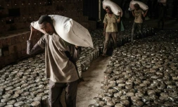 Des ouvriers transportent des sacs de blé pour 4.503 personnes ayant fui les violences dans la région éthiopienne du Tigré, à Mekele le 22 juin 2021