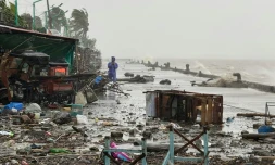 Un homme se tient à côté de débris près du bord de mer, le 22 septembre 2025 à Aparri aux Philippines