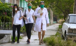 La docteure cubaine Liz Caballero (d) fait du porte-Ă -porte avec des Ă©tudiantes, en quĂȘte de nouveaux cas de coronavirus,le 31 mars 2020 Ă La Havane