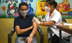 Une infirmière administre une dose de vaccin anti Covid-19 dans un centre de vaccination de New Delhi le 21 juin 2021