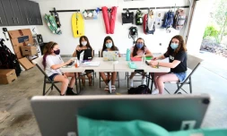 Des collégiennes suivent le cours en ligne de leur tuteur sur un iPad dans un garage, le 27 août 2020 à Calabasas, en Californie