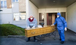 Des employés d'une société de pompes funèbres avec le cercueil d'une victime du coronavirus en EHPAD, à Mulhouse le 5 avril 2020