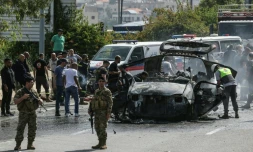 Des secouristes autour d'un véhicule ciblé par une frappe de drone israélien sur une autoroute près de la ville de Jiyeh, au sud de Beyrouth, le 13 mai 2026 au Liban