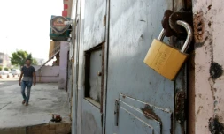 Un Irakien passe devant la porte fermée d'un magasin vendant de l'alcool à Bagdad le 23 octobre 2016 