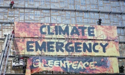 Des militants de Greenpeace évacués par des pompiers après avoir déployé une bannière sur le bâtiment du conseil européen à Bruxelles le 12 décembre 2019