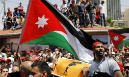 Des Jordaniens brandissent le drapeau national et scandent des slogans contre l'austérité, le 6 juin 2018 à Amman