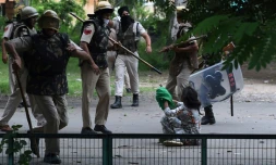 Un adepte de Gurmeet Ram Rahim Singh face aux forces de l'ordre indiennes lors de heurts après la condamnation pour viol du gourou, le 25 août 2017 à Panchkula