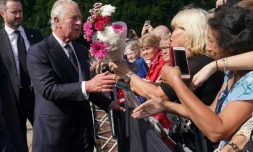 Le roi Charles III salue la foule à son arrivée au palais de Buckhingham, au lendemain du décès de la reine Elizabeth II, le 9 septembre 2022 à Londres