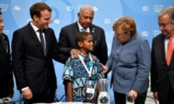 Timoci Naulusala un petit fidjien est félicité par le président Emmanuel Macron (g) et la chancelière Angela Merkel après son discours devant la COP 23 à Bonn