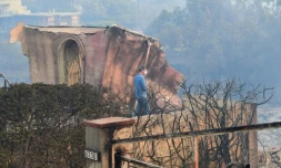 Un membre des services du sheriff du comté de Los Angeles marche au milieu de propriétés dévastées par les flammes à Malibu, en Califonrie, le 10 novembre 2018.