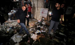 Des Irakiens inspectent les dégâts dans un marché de Bagdad après un attentat meurtrier, le 19 juillet 2021