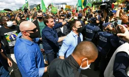 Le président du Brésil Jair Bolsonaro sans masque accueille ses supporters, lors de son arrivée au palais présidentiel à Brasilia, le 24 mai 2020