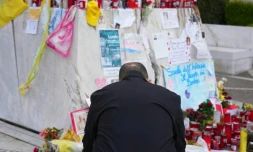 Un homme prie au pied de la statue de Jean-Paul II devant l'hôpital Gemelli à Rome où est soigné le pape François pour une pneumonie, le 9 mars 2025