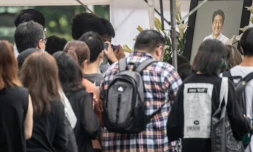 Des Japonais dĂ©posent des fleurs devant le temple de Tokyo oĂč ont lieu mardi les funĂ©railles de l'ex-Premier ministre Shinzo Abe le 12 juillet 2022