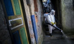 Un volontaire désinfecte une rue dans la favela Santa Marta de Rio de Janeiro le 20 avril 2020 dans le cadre de la lutte contre le coronavirus