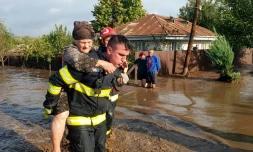 Un secouriste évacue une femme âgée, le 14 septembre 2024, dans le village inondé de Pechea, en Roumanie