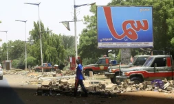 Un homme traverse une rue où sont postés des membres des Forces de soutien rapide (RSF), des paramilitaires accusés d'être à l'origine d'une vague de répression meurtrière, à Khartoum, le 10 juin 2019