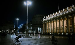 Un livreur à vélo passe devant le Grand Théâtre à Bordeaux le 29 octobre 2020, avant la mise en place du deuxième confinement national dans le pays