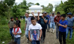 Un garçon porte une photo de Jakelin Caal, décédée aux Etats-Unis, pendant ses obsèques au Guatemala le 25 décembre 2018