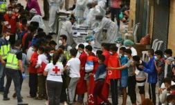 Des jeunes migrants font la queue pour un test ant-Covid à leur arrivée à Ceuta, le 19 mai 2021 en Espagne