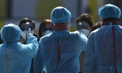 Des agents sanitaires prennent la température des passagers débarqués du navire de croisière Diamond Princess, le 21 février 2020 à Yokohama, au Japon