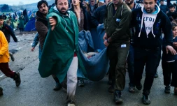 Evacuation d'une femme blessée lors d'une distribution de nourriture le 10 mars 2016 à Idomeni à la frontiÚre de la GrÚce et de la Macédoine