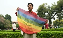 Un militant tient un drapeau arc-en-ciel lors d'un rassemblement devant la Cour suprĂȘme de l'Inde le 17 octobre 2023 Ă New Delhi