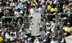 Des fidèles égyptiens brandissent un carton à l'image du pape Francis avant le début d'une messe le 29 avril 2017 dans un stade au Caire