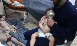 Une image prise sur une vidéo de la Défense civile syrienne montre des volontaires aidant des enfants victimes d'une attaque chimique présumée à Douma, le 8 avril 2018