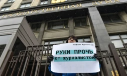 Une femme manifeste devant la Douma, chambre basse du Parlement russe, avec une affiche "Bas les pattes des femmes journalistes", le 21 mars 2018