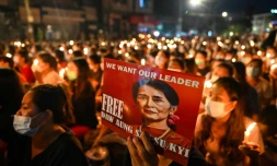 Un manifestant tient une affiche avec une image de l'ex-dirigeante détenue Aung San Suu Kyi lors d'une veillée aux chandelles à Rangoun, le 13 mars 2021