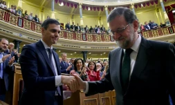 Mariano Rajoy serre la main de Pedro Sanchez (g) après avoir été renversé par le Parlement, le 1er juin 2018 à Madrid