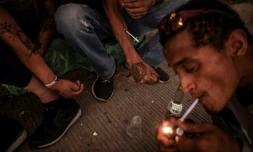 Un toxicomane fume du crack tandis que d'autres s'injectent de l'héroïne dans le centre-ville de Medellin, en Colombie, le 1er mars 2022