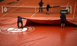 Des officiels retirent la bâche sur le court Simonne-Mathieu à Roland-Garros, le 30 mai 2024