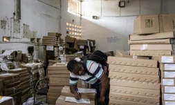 Un membre de la commission électorale sierra-léonaise répertorie des boîtes de bulletins avant l'élection présidentielle, à Freetown, le 23 juin 2023