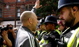 Un manifestant fait un signe à un contre-manifestant à Nottingham, dans le centre de l'Angleterre, le 3 août 2024 lors d'une manifestation sous le mot d'ordre anti-immigration: "Enough is Enough" (Trop c'est trop)
