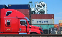 Un camion passe devant des conteneurs, dont l'un appartenant au groupe chinois Cosco, le 6 juillet 2018 dans le port de Long Beach, en Californie