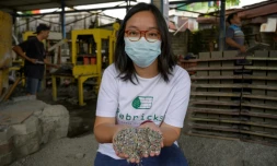 Novita Tan, cofondatrice de Rebrick, montre des déchets plastiques réduits en petits morceaux qui seront transformés en briques, le 7 avril 2021 à Jakarta, en Indonésie