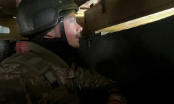 Un soldat ukrainien surveille depuis un abri les lignes de l'armée russe, près de Kharkiv, le 17 avril 2022