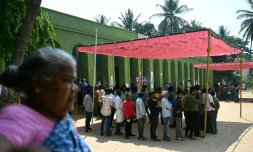 Des électeurs, à l'abri du soleil sous un auvent, attendent pour voter, le 26 avril 2024 à Bangalore, en Inde