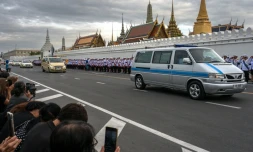 Des Thaïlandais assistent au passage du cortÚge funÚbre amenant la dépouille de la reine mÚre Sirikit au Palais royal de Bankok, le 26 octobre 2025