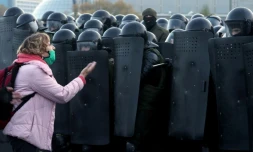 Une femme parle avec des policiers anti-émeute pendant une manifestation à Minsk, le 25 octobre 2020. 