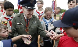 L'ancien pilote américain Gail Halvorsen - qui a participé au pont aérien de Berlin - distribue des bonbons aux membres d'une équipe berlinoise de baseball et à des scouts américains, lors d'une cérémonie sur l'ancien aéroport de Tempelhof, à Berlin le 11 mai 2019
