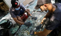 des ouvriers trient le verre cassé lors de l'explosion au port de Beyrouth pour le recycler à Tripoli, la ville portuaire du nord du Liban le 25 août 2020